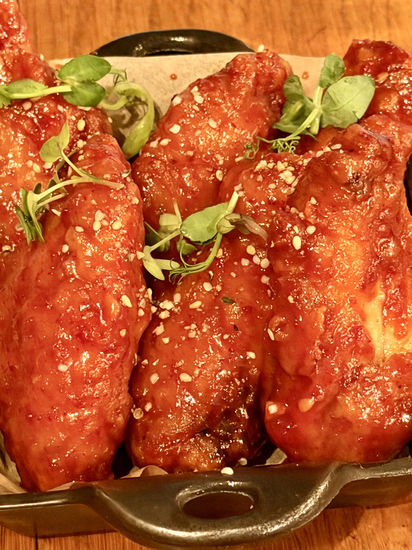 Glazed fried chicken wings with sesame seeds and herbs