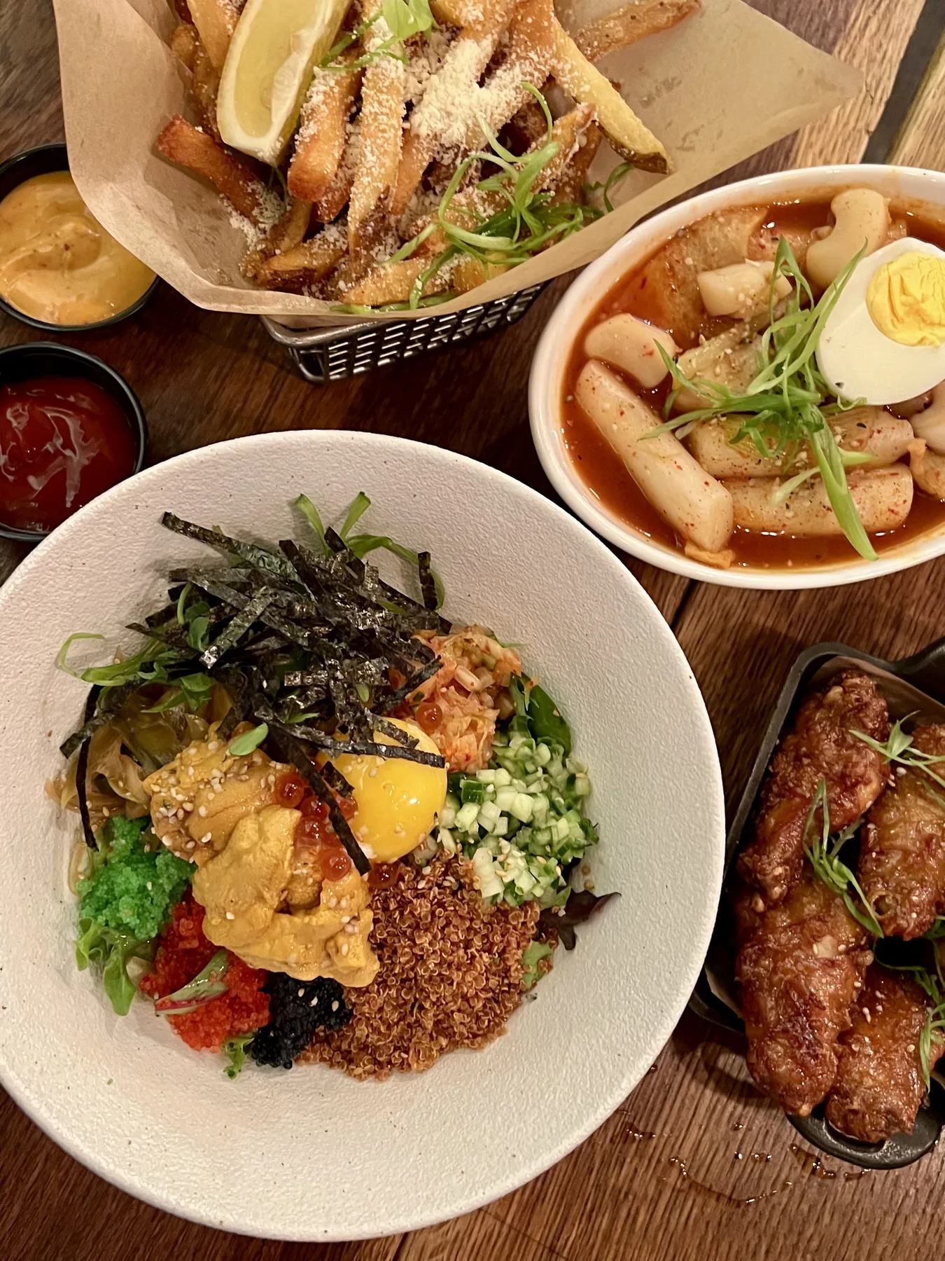 Bibimbap and tteokbokki spread on a wooden table