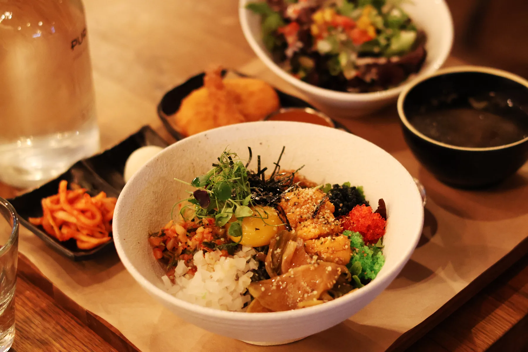 A bowl of bibimbap surrounded by side dishes